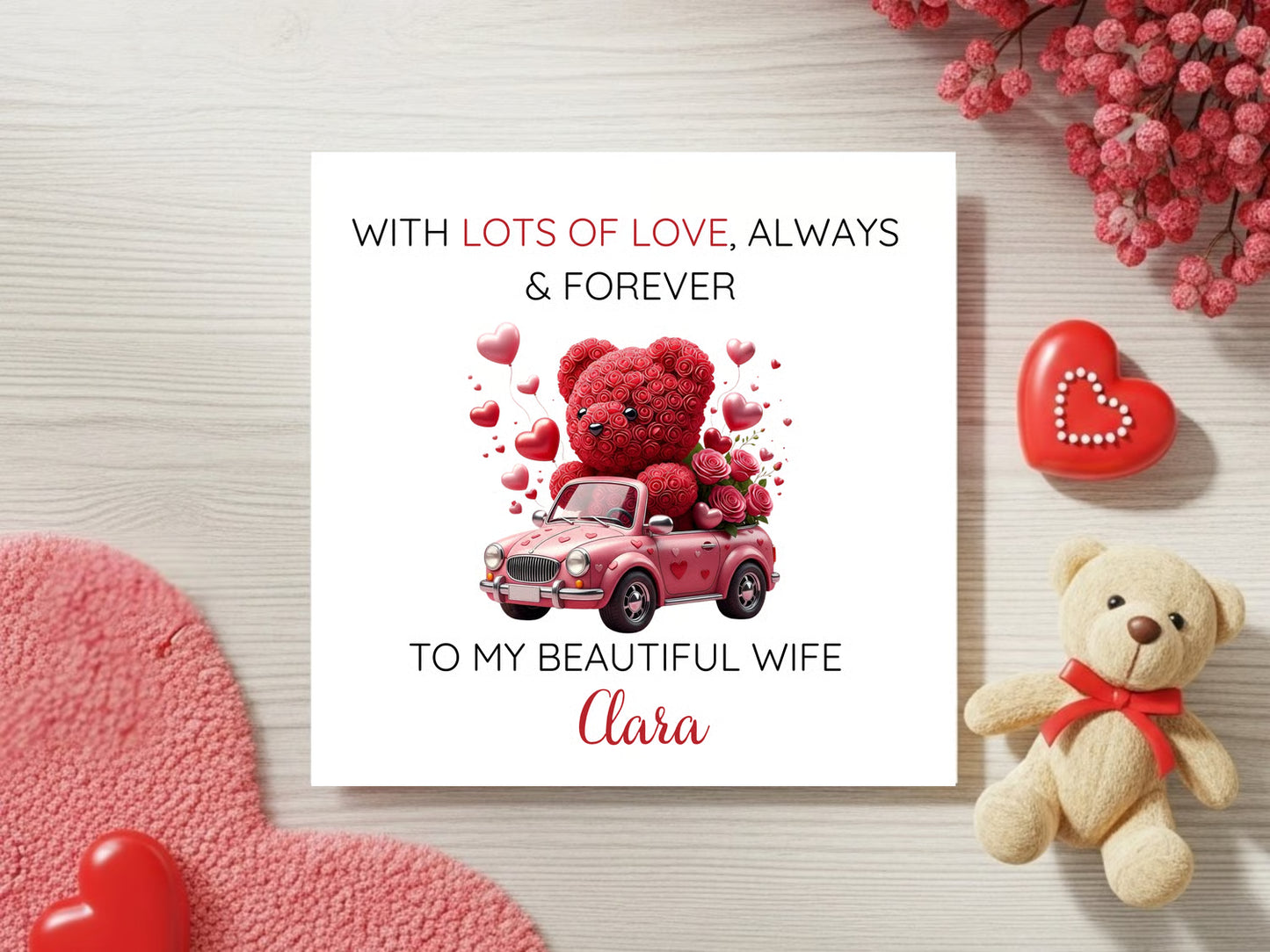Valentine's Day card with teddy bear and car illustration, surrounded by decorative elements on a wooden surface.